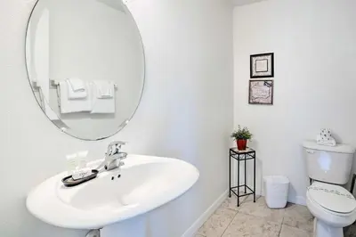 a white bathroom with a sink and a mirror at Dog-Friendly Kissimmee Home with Lanai and Pool! in Kissimmee