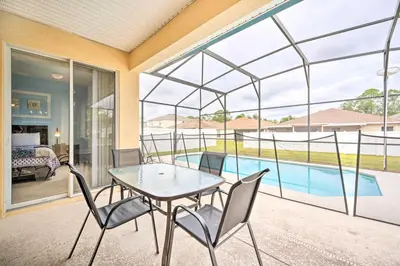 a patio with a table and chairs and a pool at Dog-Friendly Kissimmee Home with Lanai and Pool! in Kissimmee