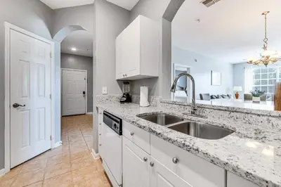 a kitchen with white cabinets and a sink at 6 Mi to Disney World Condo with Community Perks! in Kissimmee