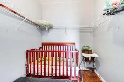 a red crib in a room with a white wall at 6 Mi to Disney World Condo with Community Perks! in Kissimmee