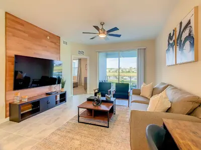 a living room with a couch and a flat screen tv at Homely Lakeview 3BR Condo with Waterpark in Kissimmee