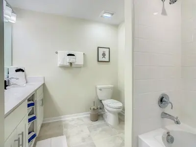 a white bathroom with a toilet and a sink at Gorgeous 2BR lakeview Condo with Waterpark in Kissimmee