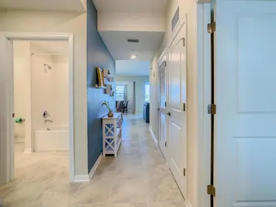 a hallway with a blue wall and a bathroom at Gorgeous 2BR lakeview Condo with Waterpark in Kissimmee