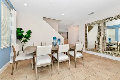 a dining room with a table and chairs and a mirror at Charming Home Near Disney With Private Pool And Waterpark & Resort Access At Encore Resorts Reunion - 7389Mr in Kissimmee