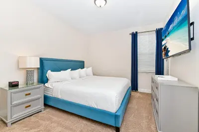 a white bedroom with a blue bed and a window at Charming Home Near Disney With Private Pool And Waterpark & Resort Access At Encore Resorts Reunion - 7389Mr in Kissimmee