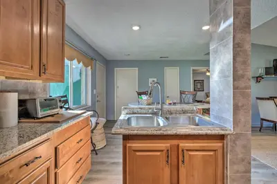 a kitchen with a sink and a microwave at about 9 Mi to Universal Orlando Retreat with Sun Porch! in Orlando