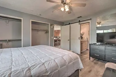a bedroom with a large bed and a flat screen tv at about 9 Mi to Universal Orlando Retreat with Sun Porch! in Orlando