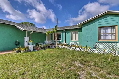 a green house with a yard in front of it at about 9 Mi to Universal Orlando Retreat with Sun Porch! in Orlando