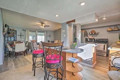a kitchen and living room with a table and chairs at about 9 Mi to Universal Orlando Retreat with Sun Porch! in Orlando