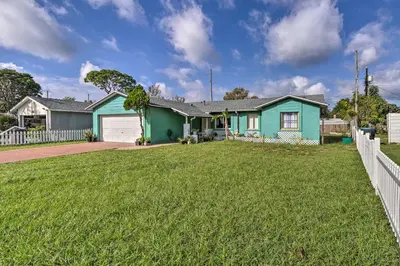 a house with a green house and a yard at about 9 Mi to Universal Orlando Retreat with Sun Porch! in Orlando