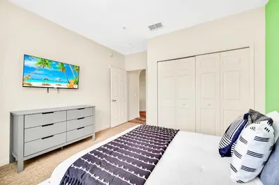 a bedroom with a bed and a tv on the wall at Upstay - Pet-Friendly Suite w Pool, Sauna in Orlando