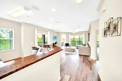 a kitchen and living room with white walls and wood floors at Upstay - Pet-Friendly Suite w Pool, Sauna in Orlando
