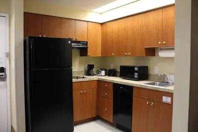a kitchen with a black refrigerator and wooden cabinets at Great Condo Incredible Location in Orlando
