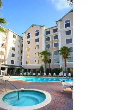 a hotel with a swimming pool in front of a building at Great Condo Incredible Location in Orlando