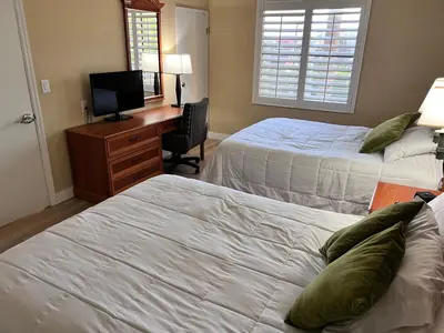 a bedroom with two beds and a desk with a television at Great Condo Incredible Location in Orlando