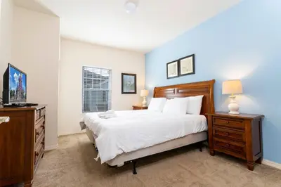 a bedroom with a large bed and a dresser and lamp at 5366 Unit 17-106 Lovely home inside Disney area in Kissimmee