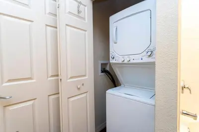 a bathroom with a washer and dryer next to a door at 5366 Unit 17-106 Lovely home inside Disney area in Kissimmee