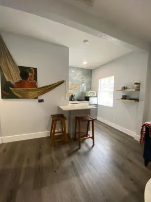a living room with a table and a hammock on the wall at Bella Breeze in Sanford