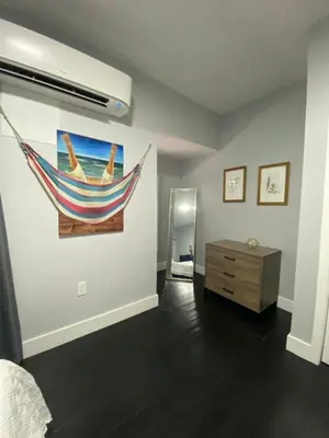 a room with a painting of a hammock on the wall at The Blue Aztec in Sanford