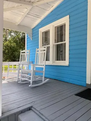 two chairs sitting on the porch of a blue house at The Blue Aztec in Sanford