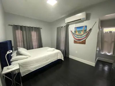a bedroom with a bed and a painting of a boat at The Blue Aztec in Sanford