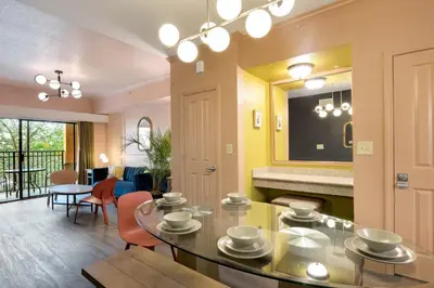 a living room with a glass table and chairs at Designer 3BR/2BA Corner Suite - Disney & Universal in Orlando