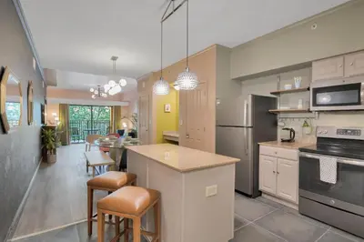 a kitchen with a counter and a dining room at Designer 3BR/2BA Corner Suite - Disney & Universal in Orlando