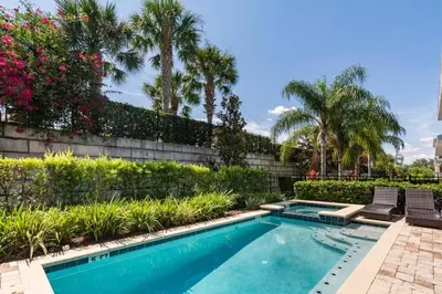 a swimming pool with two chairs and trees and plants at Luxurious Encore Villa 10 Min Disney Inc/Waterpark in Orlando