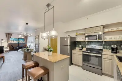 a large kitchen with a counter and a dining room at Designer Corner Suite 3BR/2BA -Disney & Universal in Orlando