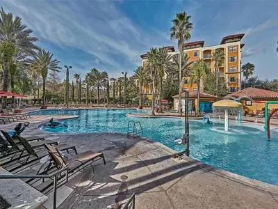 a swimming pool at a resort with palm trees at Designer Corner Suite 3BR/2BA -Disney & Universal in Orlando