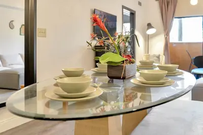 a glass table with cups and saucers on it at Designer Corner Suite 3BR/2BA -Disney & Universal in Orlando