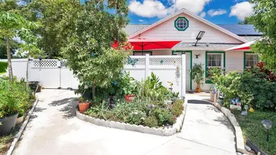 a house with a white fence and a garden at La Maison de Lorbu - Apartment in Orlando