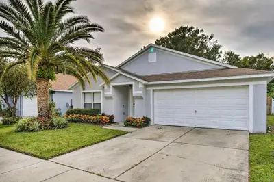 a house with a palm tree and a garage at Chic Orlando Family Getaway with Fenced Yard! in Orlando