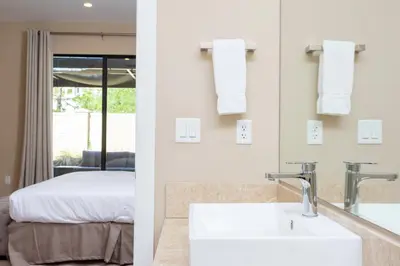 a bathroom with a sink and a bedroom with a bed at 4 Suites - 5 min from Disney - w Jacuzzi 7557 in Orlando