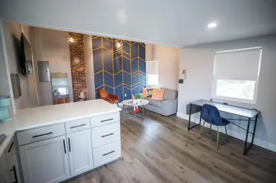 a kitchen with a desk and a living room at The Contemporary in Sanford