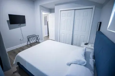 a bedroom with a white bed and a door at The Contemporary in Sanford