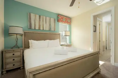 a bedroom with a large white bed and a nightstand at Encore Resort 11 Bedroom Home with Pool 2206 in Orlando