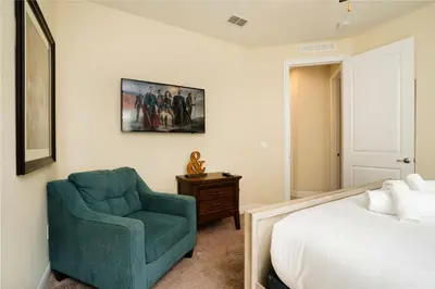 a bedroom with a green chair and a bed at Encore Resort 11 Bedroom Home with Pool 2206 in Orlando