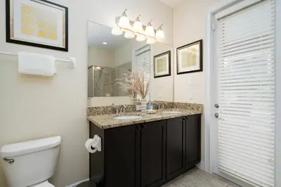 a bathroom with a sink and a toilet and a mirror at Encore Resort 11 Bedroom Home with Pool 2206 in Orlando