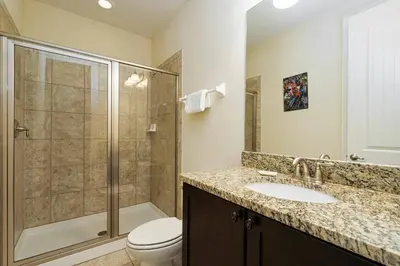 a bathroom with a shower and a toilet and a sink at Encore Resort 11 Bedroom Home with Pool 2206 in Orlando