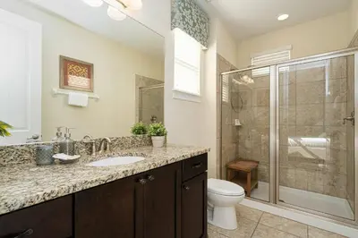a bathroom with a toilet and a sink and a shower at Encore Resort 11 Bedroom Home with Pool 2206 in Orlando