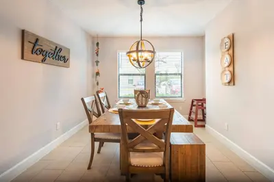 a dining room with a wooden table and a chandelier at 3BR Resort Pool Jacuzzi Minutes to Disney 4730 in Kissimmee
