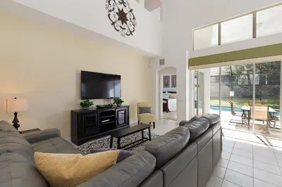 a living room with a couch and a flat screen tv at Windsor Dream - 6 bedroom resort pool home in Orlando