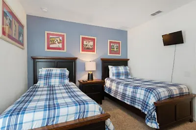 a bedroom with two beds and a flat screen tv at Windsor Dream - 6 bedroom resort pool home in Orlando