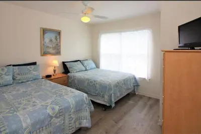 a bedroom with two beds and a flat screen tv at Family Friendly 3BR near Disney in Kissimmee