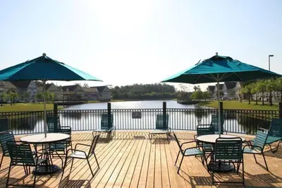 a deck with tables and chairs and umbrellas at Family Friendly 3BR near Disney in Kissimmee