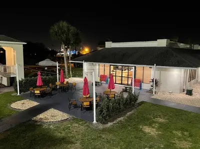 a group of tables and chairs with umbrellas at night at Newly Room in cozy hotel with Super location to the Parks in Kissimmee
