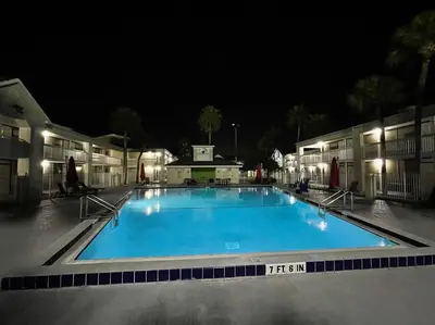 a large swimming pool at night with lights at Newly Room in cozy hotel with Super location to the Parks in Kissimmee