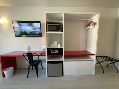 a room with a desk and a microwave and a table at Newly Room in cozy hotel with Super location to the Parks in Kissimmee