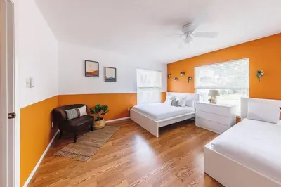 a bedroom with a bed and a couch and a chair at Orlando Boho Villa in Kissimmee